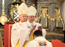 Abp Marek Jędraszewski nakłada dłonie na głowę bp. Wojciecha Osiala. Za nim bp Andrzej F. Dziuba