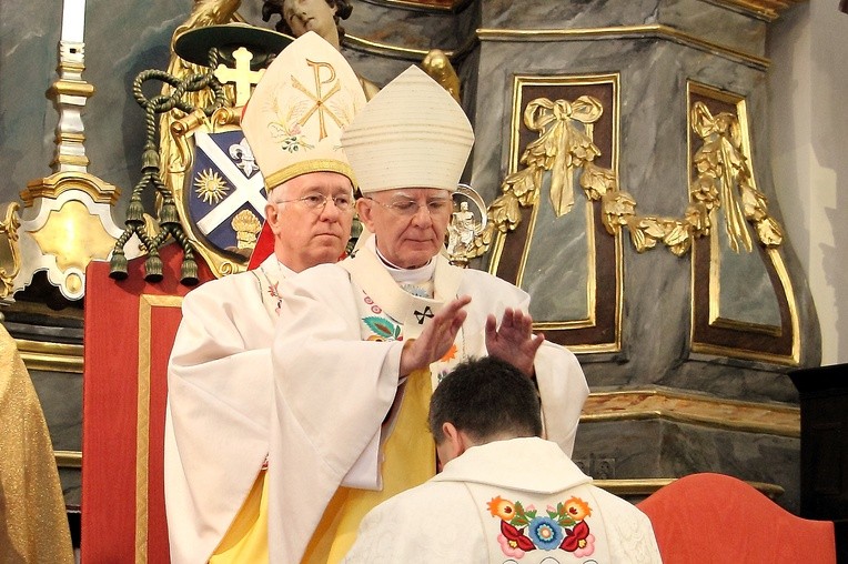 Abp Marek Jędraszewski nakłada dłonie na głowę bp. Wojciecha Osiala. Za nim bp Andrzej F. Dziuba