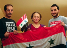 Od lewej: Nidal, Lena i Rafi w swoim opolskim mieszkaniu  z flagą Syrii.