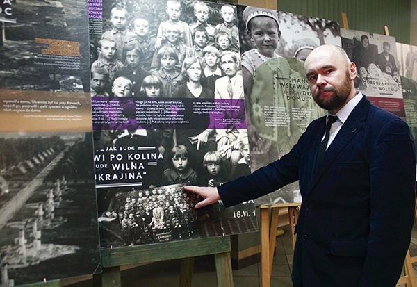 ▲	Historyk wskazuje zawarte na wystawowych panelach tragiczne losy dzieci ze szkoły w Zagajach.