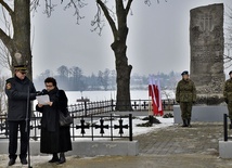 O hitlerowskiej zbrodni mówiła Mirosława Krysiak. W oddali, widoczne miejsce faktycznego mordu: z przekrzywionym krzyżem