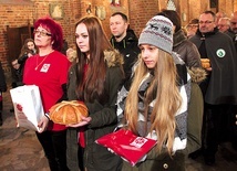 Osoby, które na co dzień pomagają potrzebującym, przyniosły w darach m.in. chleb, czapkę, szal i rękawiczki jako symbol pomocy niesionej osobom bezdomnym.
