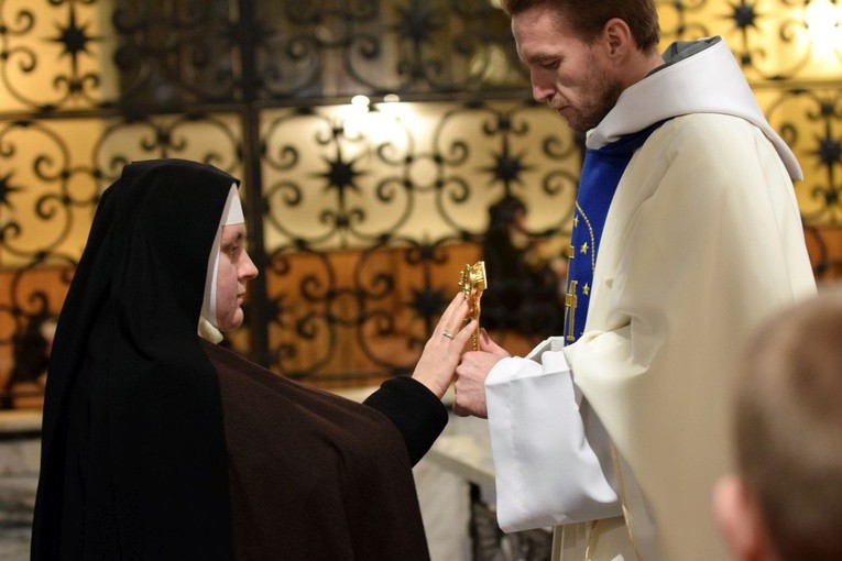 Jedna z sióstr dotykająca relikwii błogosławionych franciszkanów.