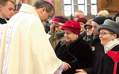 Biskup Tadeusz Lityński udziela sakramentu namaszczenia chorych, znaku czułego dotknięcia Boga.