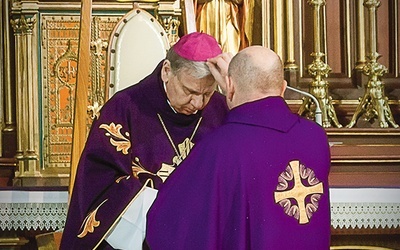 Proboszcz gliwickiej katedry ks. Bernard Plucik posypuje popiołem głowę biskupowi Janowi Kopcowi.
