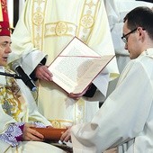 Daniel Kołodziejczyk przyjmuje od bp. Adama Pismo Święte.