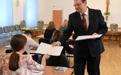 Tomasz Dziurla wręczający gratulacje szkołom uczestników biorących udział w konkursie.