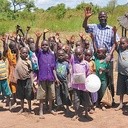 Ksiądz David Okullu z dziećmi z wioski. Ks. David prowadzi organizację, ktora pomaga w rozwoju lokalnych społeczności. 