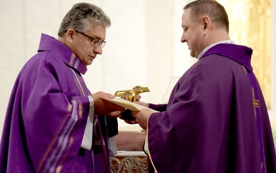 Ojciec franciszkanin wręczył na ręce proboszcza relikwie o. Michała i o. Zbigniewa.