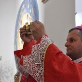 Biskup Leszkiewicz ukazuje dar kaganka, który ofiarowali młodzi w Szczawie 