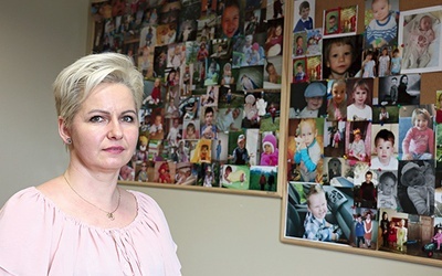 ▲	Elżbieta Stolarczyk, a w tle zdjęcia dzieci, którym udało się pomóc.