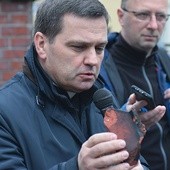 Ks. Wiesław Rusin pokazywał zebranym kawałki cegieł, które spadają ze szczytu świątyni.