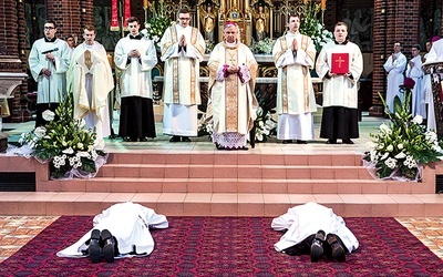 Ks. Jan Opiełka i ks. Denis Rakwic leżą krzyżem w trakcie Litanii do Wszystkich Świętych, tuż przed udzieleniem sakramentu kapłaństwa.