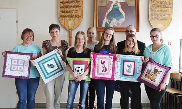 Uczestniczki nagrodzonego projektu „Współcześni Samarytanie” z opiekunami pod szkolną tablicą patronki św. Jadwigi i ich „Celinki”.