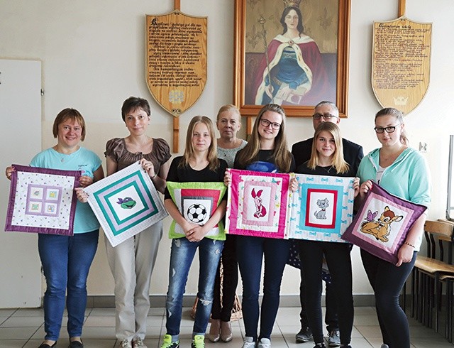 Uczestniczki nagrodzonego projektu „Współcześni Samarytanie” z opiekunami pod szkolną tablicą patronki św. Jadwigi i ich „Celinki”.