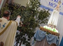 Proboszcz parafii, ks. Paweł Paździur okadza figurę Matki Bożej.