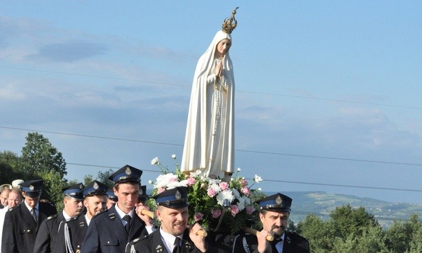 Strażacy niosący figurę Matki Bożej Fatimskiej