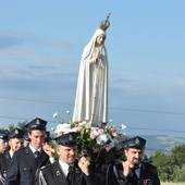 Strażacy niosący figurę Matki Bożej Fatimskiej