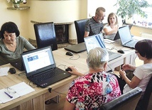 Grupa seniorów z klubu Pod Magnolią podczas warsztatów komputerowych.
