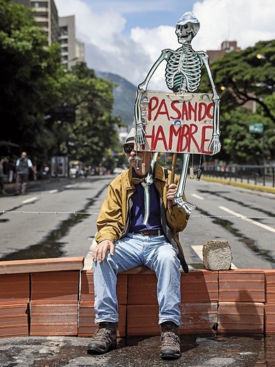 Głoduję – informuje napis na transparencie w dłoni mieszkańca Caracas. Wenezuelska Caritas ostrzega, że w nędzy żyje ponad 80 proc. mieszkańców kraju