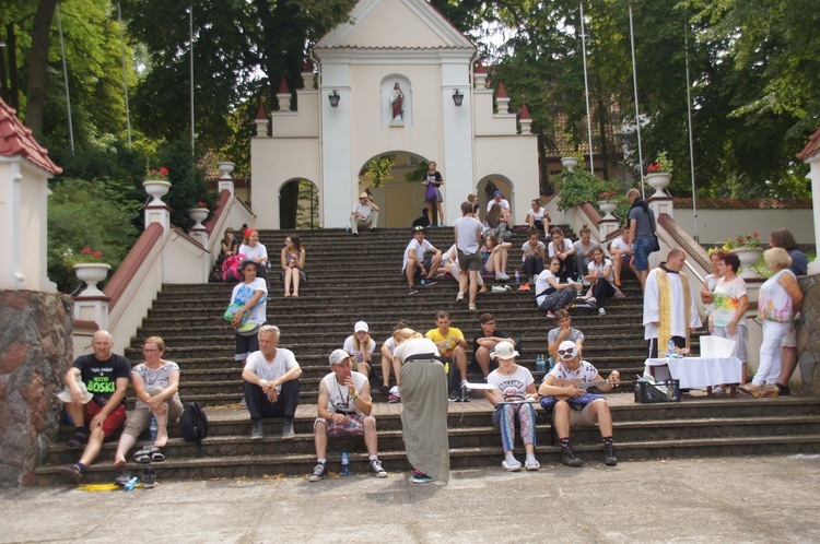 Chwila wytchnienia dla pielgrzymów na schodach przed kościołem w Strzygach