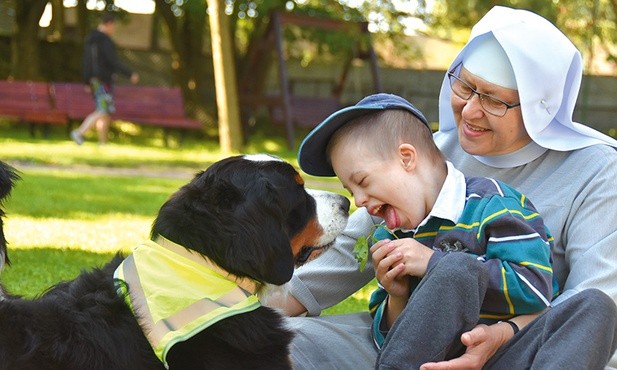 Siostra Maria Dębowska, dyrektorka Tęczowego Domu, i jeden z wychowanków w czasie dogoterapii. Podczas sesji terapeutycznej psom zakładane są specjalne odblaskowe chusty.