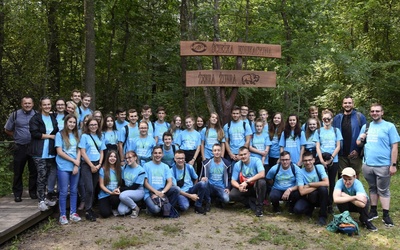 Młodzi spacerowali pierwszą leśną ścieżką przyrodniczą w Polsce - Żebra Żubra. Z lewej ks. Grzegorz Łabądź
