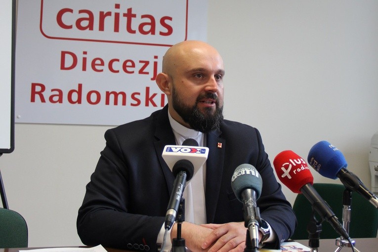 Ks. Damian Drabikowski podczas konferencji prasowej w siedzibie Caritas