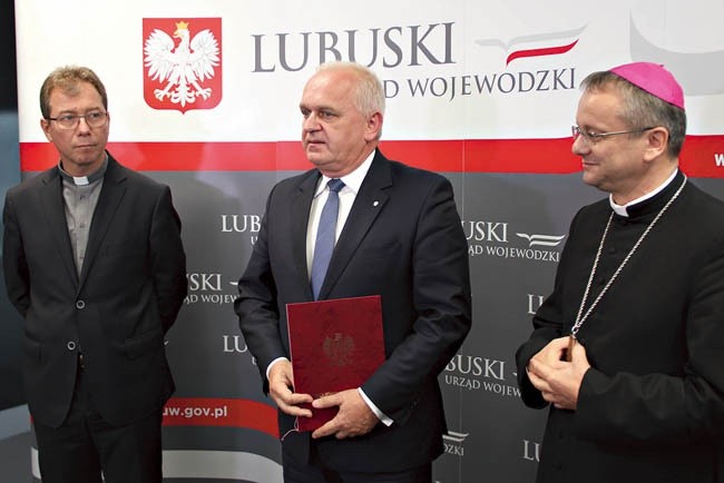 Wojewoda lubuski Władysław Dajczak przekazuje  bp. Tadeuszowi Lityńskiemu zarządzenie, które 7 września podpisała premier Beata Szydło.