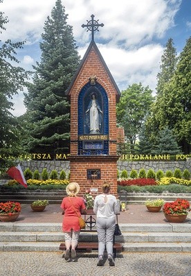 Tuż przy klonie przed głównym wejściem do kościoła po lewej stronie stoi kapliczka z figurą Niepokalanej. Postawiono ją  na prośbę Matki Bożej. Tu zawsze pielgrzymi zatrzymują się na modlitwę