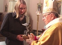 Aleksandra Golińska z Płocka odebrała statuetkę św. Michała Archanioła z rąk bp. Romana Marcinkowskiego.
