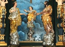 Artysta przedstawił Pana Jezusa stojącego dzielnie na palmie, w towarzystwie Maryi i św. Józefa.