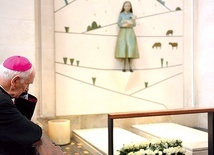 Biskup Ignacy modlący się przy grobie wizjonerów.