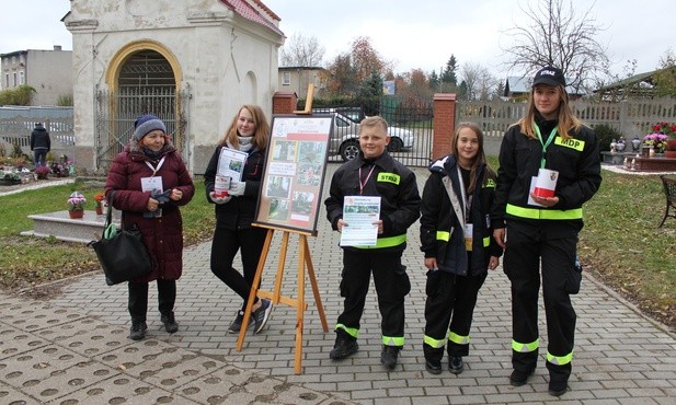 Wolontariusze podczas kwesty na międzyleskim cmentarzu. Trójka z nich należy do Młodzieżowej Straży Pożarnej. Młodzi postanowili weprzeć swoją nauczycielkę w tym projekcie