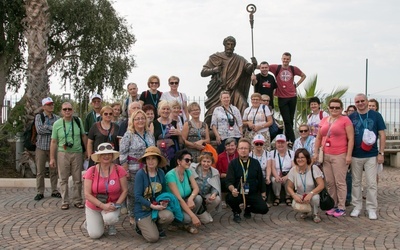Pielgrzymi z ks. Jackiem Kucharskim w Kafarnaum przed pomnikiem św. Piotra