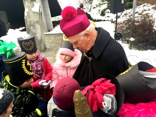 Biskup pod pomnikiem rozdał dzieciom obrazki.