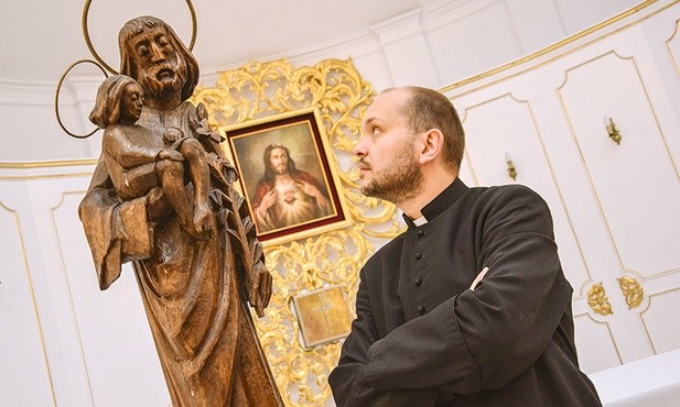 Ksiądz Marcin Gołębiewski i dębowa figurka św. Józefa z Dzieciątkiem.