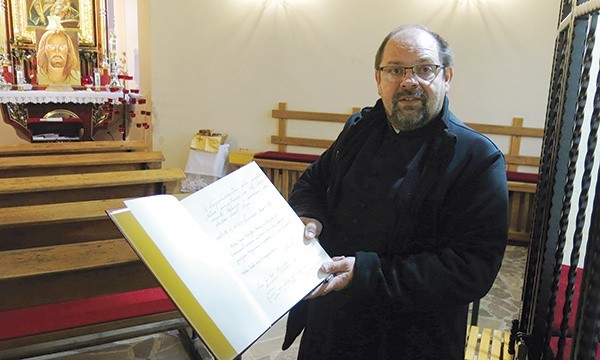 ▲	Ks. Marian Mazurek z księgą adoracji, zapisaną przez wiernych odwiedzających kościół w ciągu dnia.