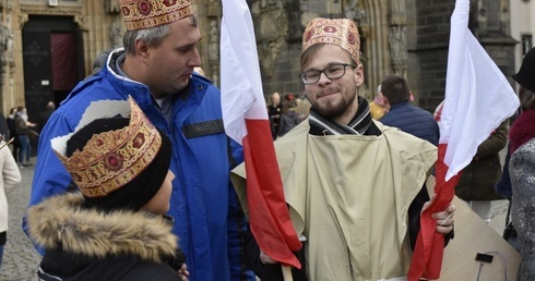 Wolontariusze rozdawali przybyłym biało-czerwone flagi.