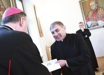 ▲	Ksiądz Janusz Kłęczek, prepozyt kapituły, odbiera nominację od  biskupa Andrzeja Jeża.