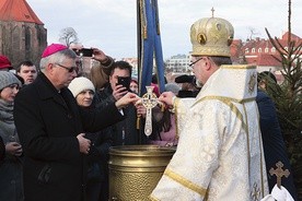 Jednym z elementów obrzędu jest zanurzenie w wodzie krzyża.