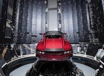 Ten sportowy samochód Tesla Roadster w kolorze wiśniowym leci w kierunku Marsa  na pokładzie rakiety Falcon Heavy.