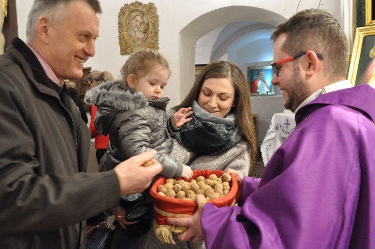 Uczestnicy Mszy św. zabierali poświęcone orzechy do domów