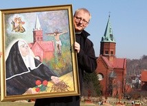 Ks. Maciej Sroczyński pokazuje obraz św. Rity z kościoła św. Jerzego i MB Różańcowej w Wałbrzychu.