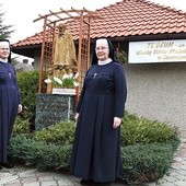 ▲	Siostry Ryszarda Chlipała (z lewej) i Wiolancja Rożek przed figurą bł. Edmunda i domem zakonnym w Skrzyszowie.