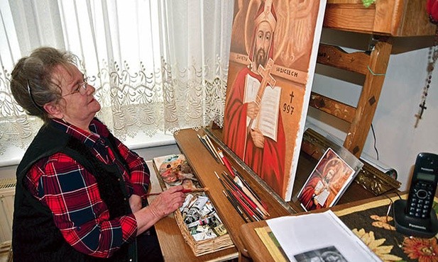 Pani Danuta w swoim kuchennym warsztacie kończy wizerunek św. Wojciecha.