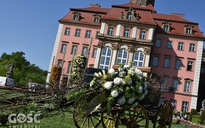 Przed budynkiem stoją okwiecone wozy, jednak najwięcej kompozycji jest w środku