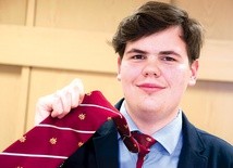 Kamil Oleszkiewicz w krawacie z logo Towarzystwa Salezjańskiego.