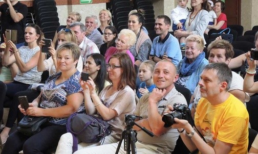 Rodzice z podziwiający swoje pociechy występujące na scenie