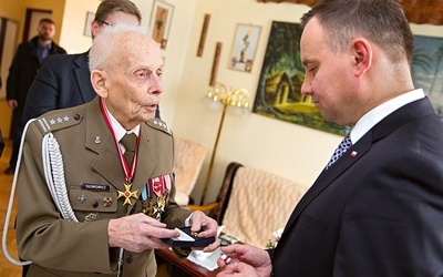 Gen. Tadeusz Bieńkowicz przekazuje prezydentowi Andrzejowi Dudzie więzienny krzyżyk.
